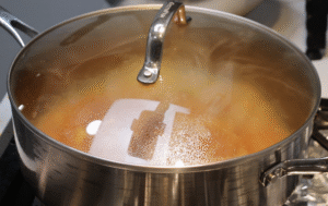 Onion getting cooked covered in a cooking pot.