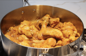Chicken frying in a large pot.