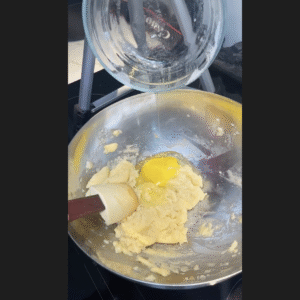 Adding eggs in the dough.